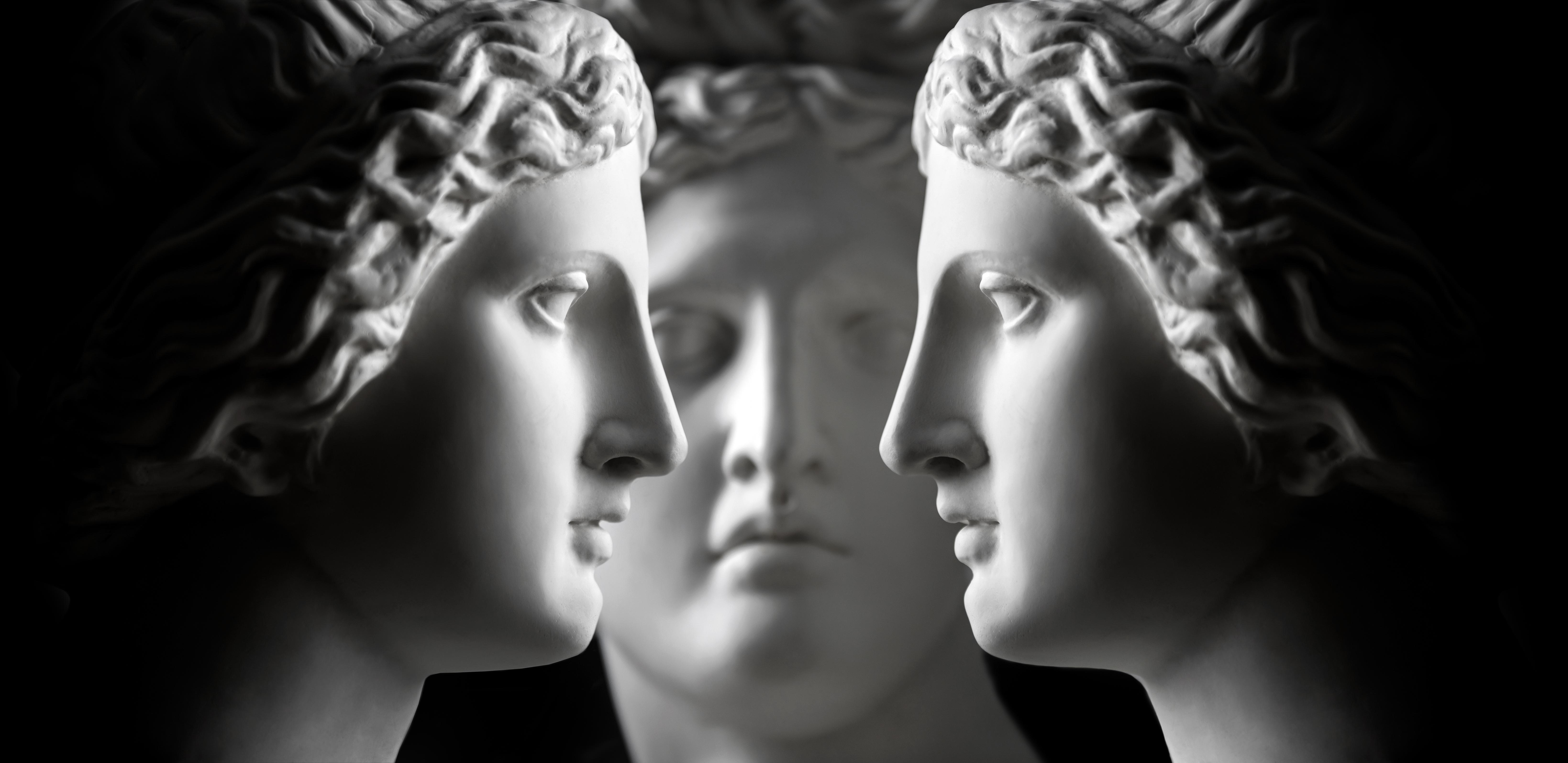 Three marble statue heads (two of Aphrodite and one of Apollo) face each other