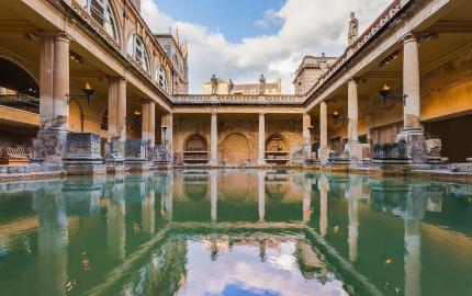 The main bath at Aquae Sulis in the modern day site in Bath, UK. Aspects of the medieval and modern city are reflected in the water.